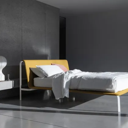 Minimal and elegant bed with fabric headboard and Bend metal frame by Bolzan Letti.