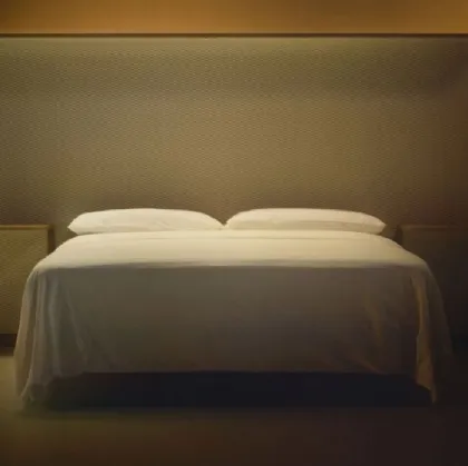 Courtoisie bed with wooden headboard and Bolzan Letti fabric.